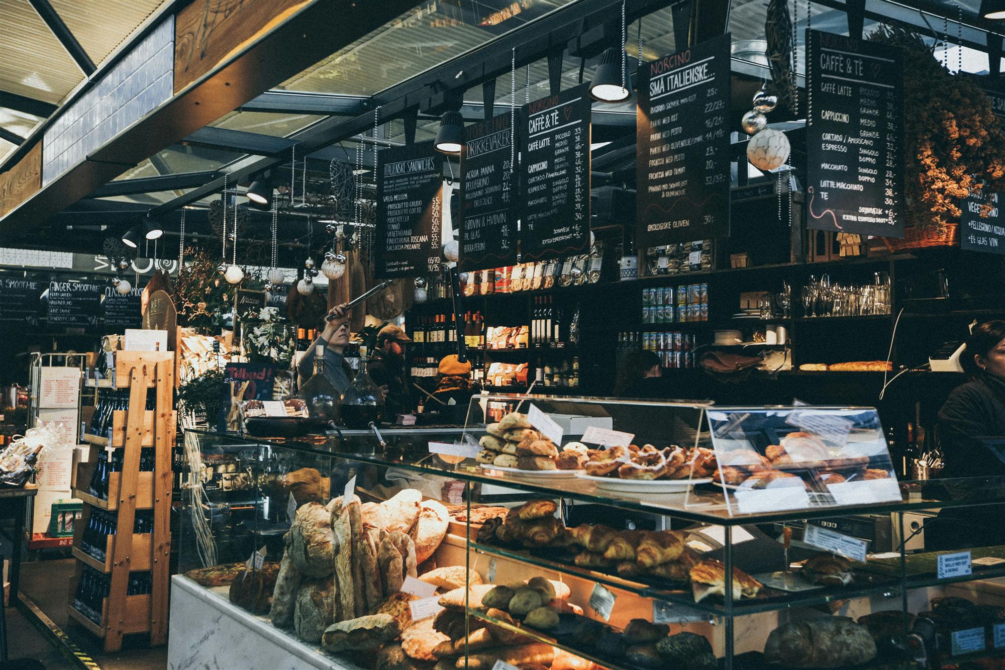 Étal de boulangerie dans une halle de marché, pains et viennoiseries en vitrine